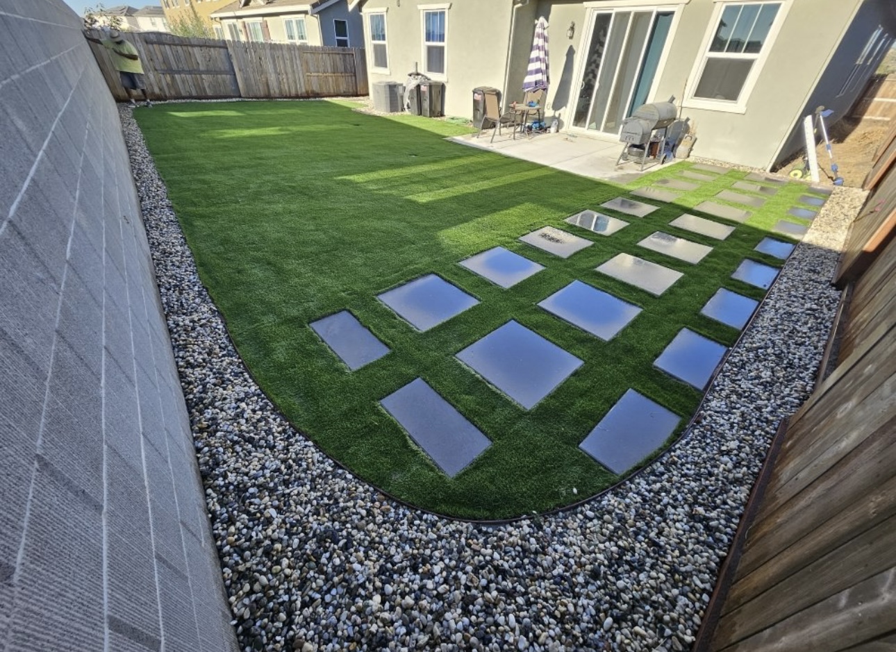 Backyard turf with stepping stones and rock