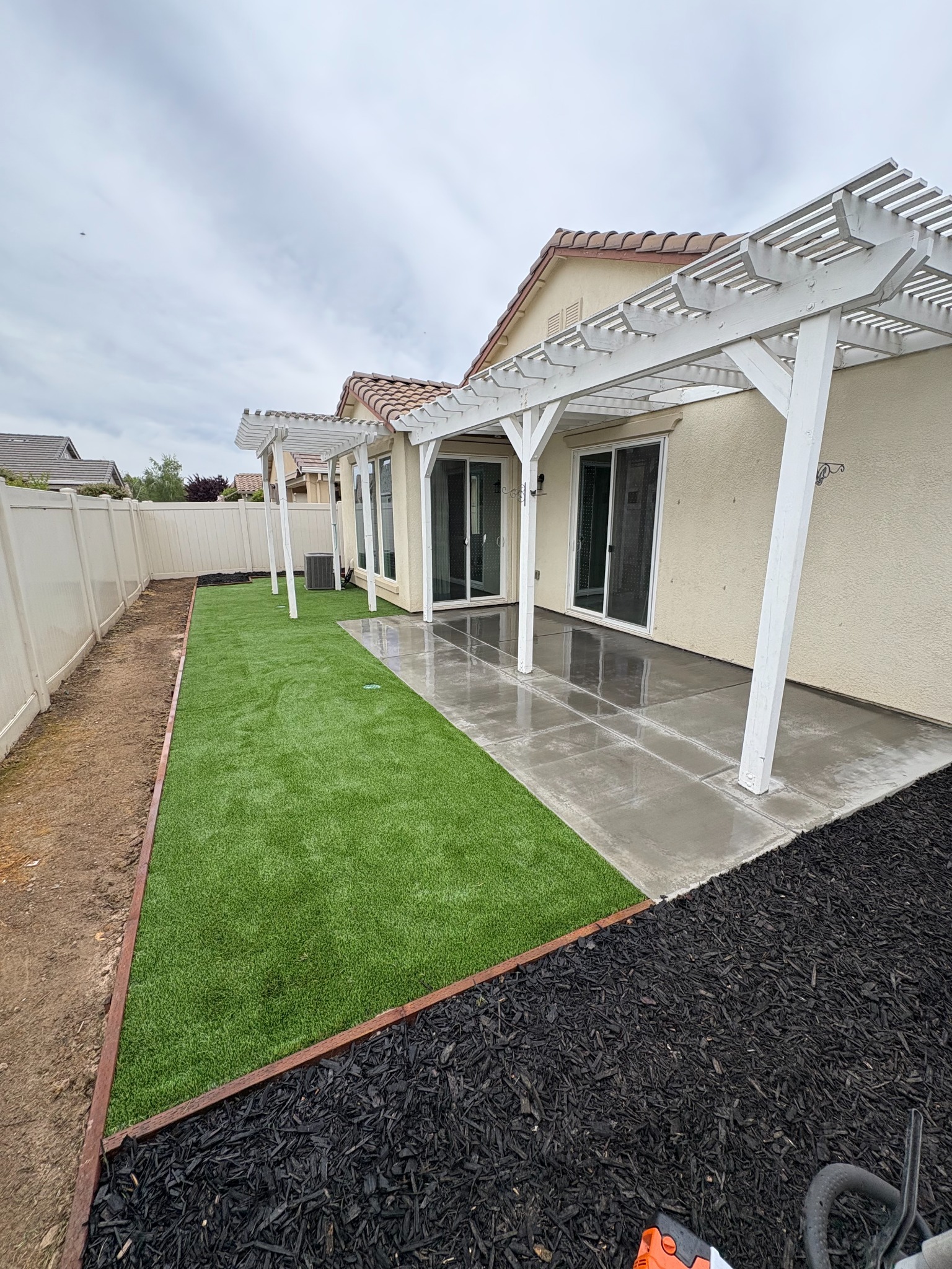 Artificial turf beside patio and mulch